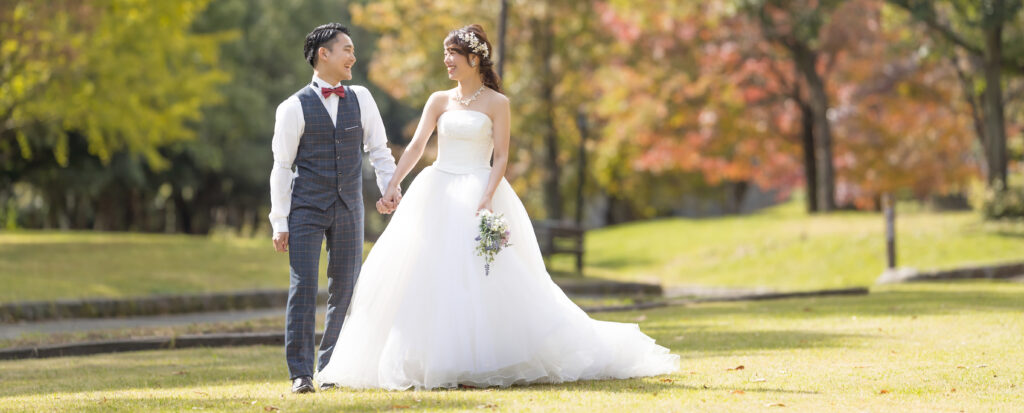 大分県別府市・別府公園でのドレス前撮り|芝生と木々を背景に歩く新郎新婦