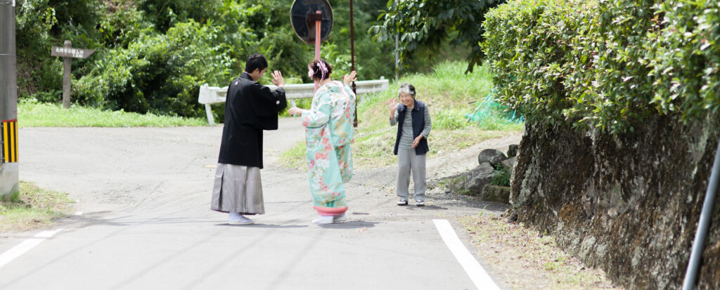大分のPhotostudio PASSIONで七五三撮影へ向かう新郎新婦と笑顔で見送る家族の自然な一枚